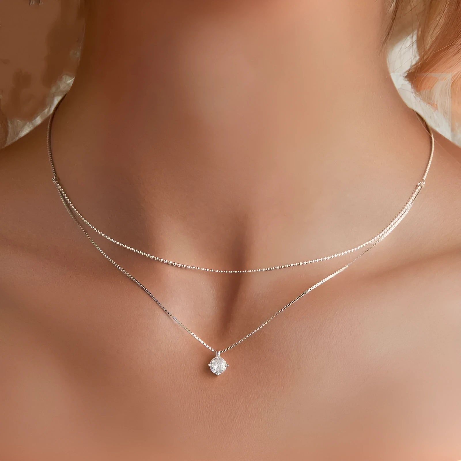 Close-up of a women's double-layer pearl chain sterling silver necklace with a matching pendant.