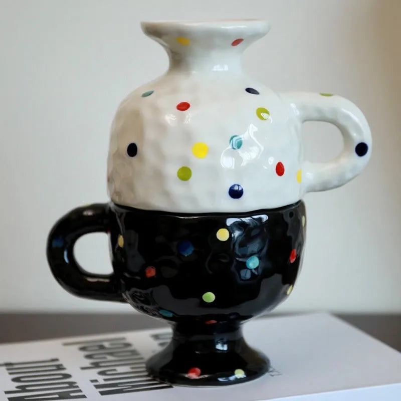 Handmade irregularly shaped ceramic mug in a solid colour, shown on a table.