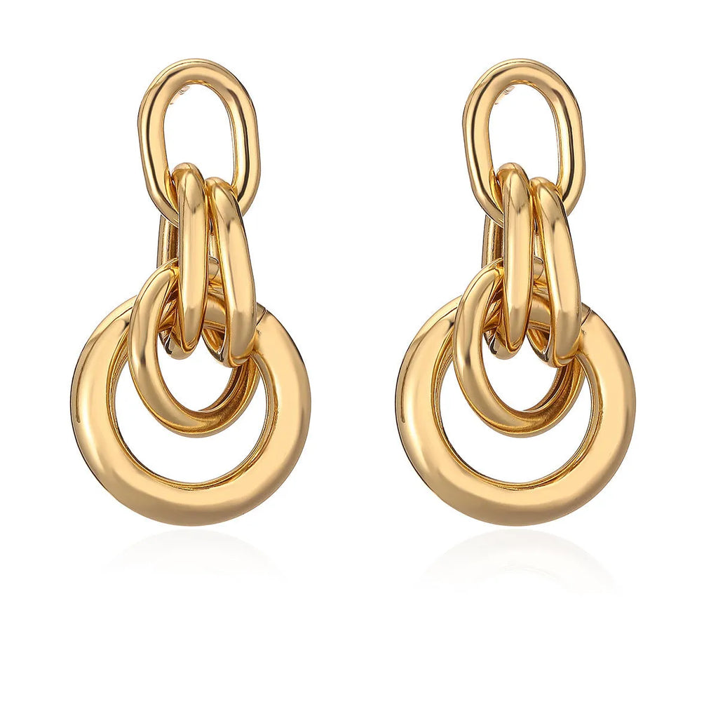 A pair of gold-coloured geometric earrings with an irregular shape on a white background.
