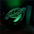 3D green turtle shaped LED night light on a table, showing multi-colour glow from its acrylic shell.