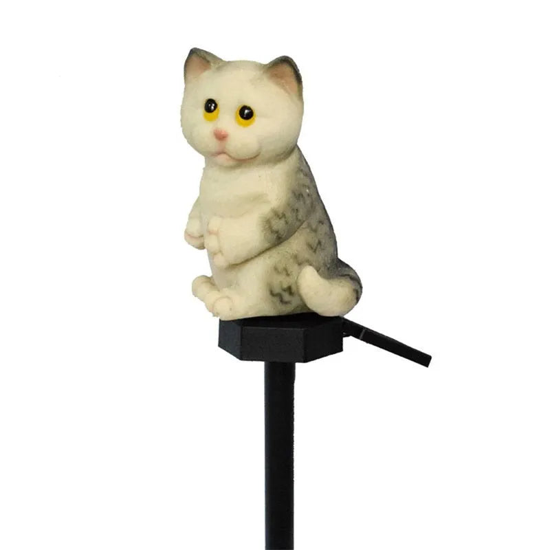 Brown resin solar-powered cat lawn light with LED illumination in a garden setting.