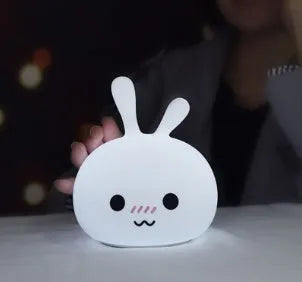 Marshmallow Bunny LED Night Light with 0.4W ABS silicone construction and happy face expression on a bedside table