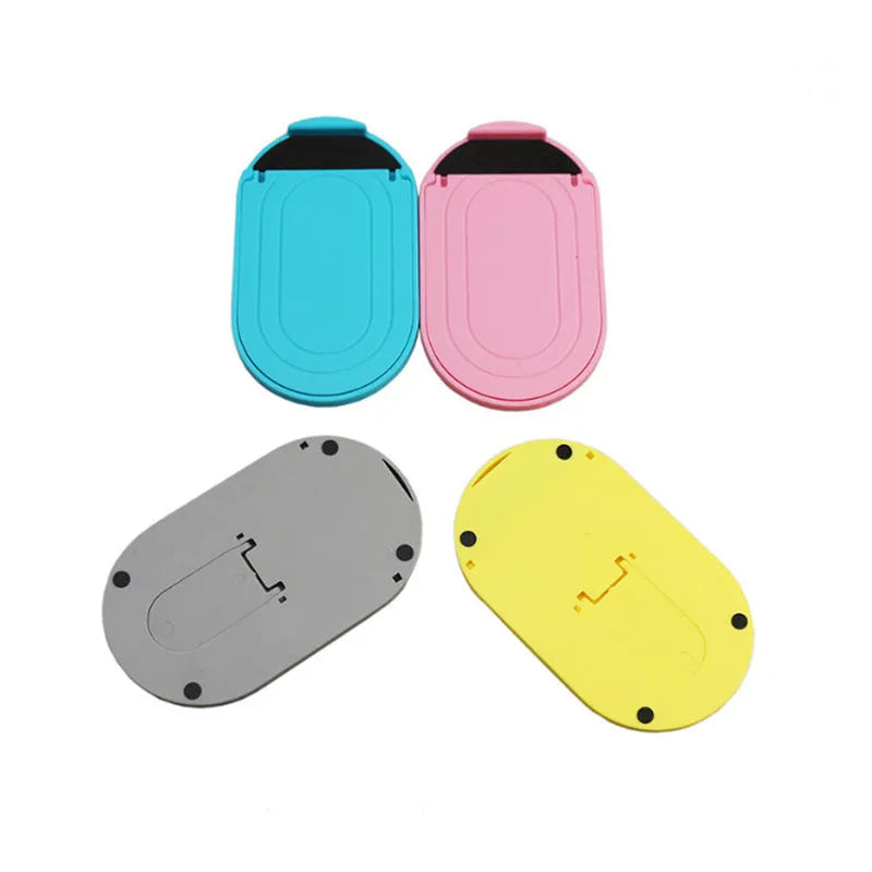 Plastic mobile phone stand with lazy bracket design in assorted colours on a desk.