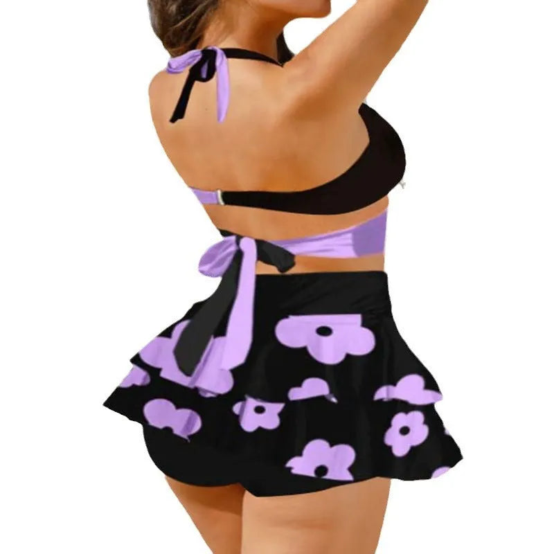 Women's black bikini set with lace-up detail and matching split skirt laid flat.