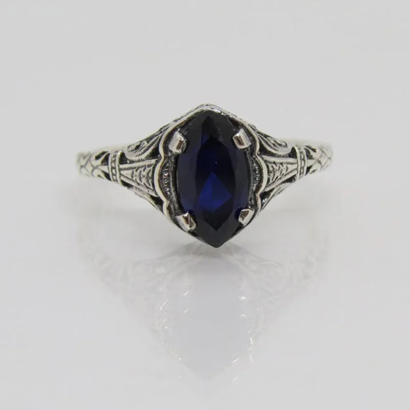 Silver geometric hollow alloy women's ring on a grey background