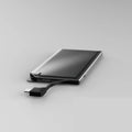 Ultra-thin black alloy card type power bank with built-in charging cable 10000mAh placed on a desk