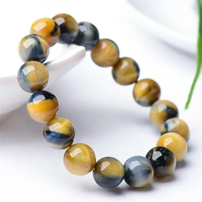 Handmade fantasy tiger eye agate bracelet with round beads on a neutral background.