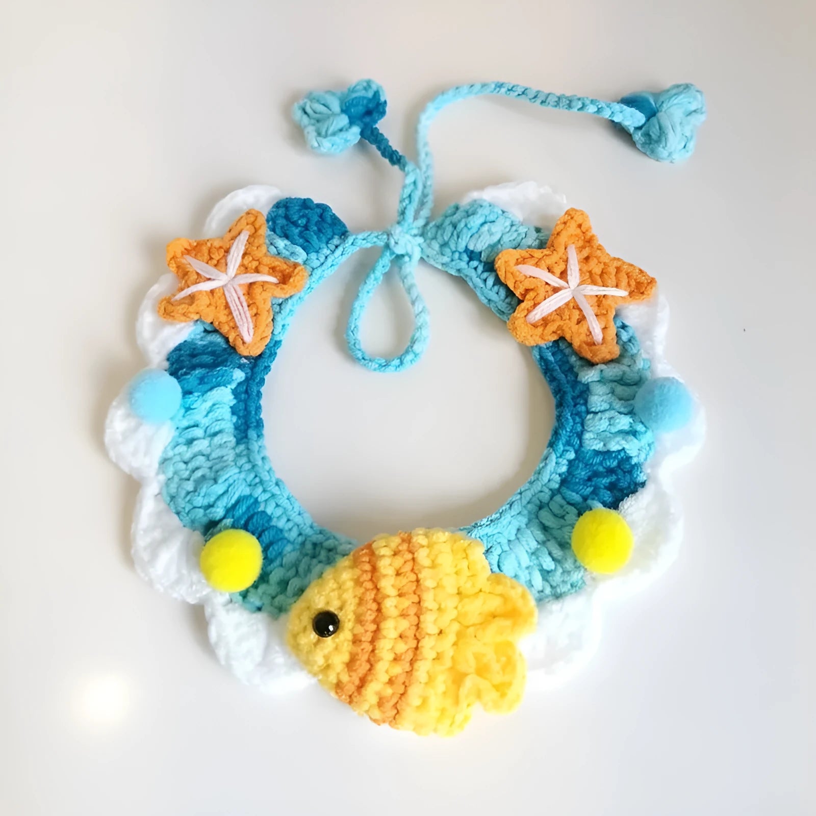 Hand-woven wool cat collar with cartoon Underwater World pattern in blue, size example on a light background