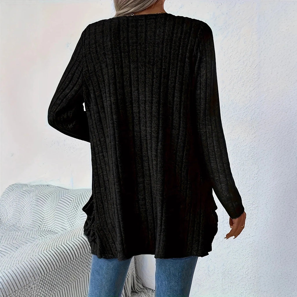 A solid colour long sleeve cardigan with pockets, shown in loose fit on a model.