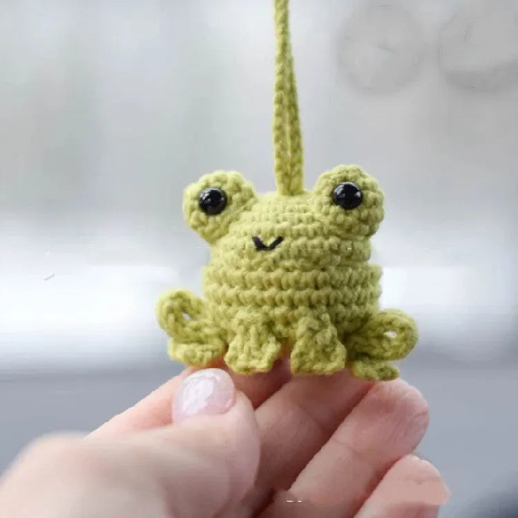 Handmade green plush frog car pendant hanging, showing woven texture and 15cm length