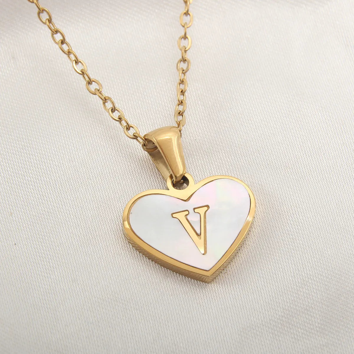 Gold plated chain necklace with a white shell heart-shaped pendant personalised with a single letter initial.