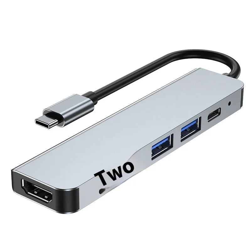 Portable silver 6-in-1 TYPE-C expansion dock with short attached cable for laptops and tablets.