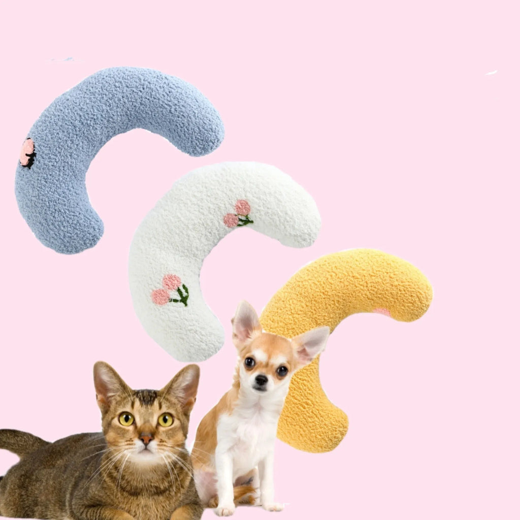 Plush white U-shaped pet pillow with raised rim for a cat or small dog to sleep curled up.