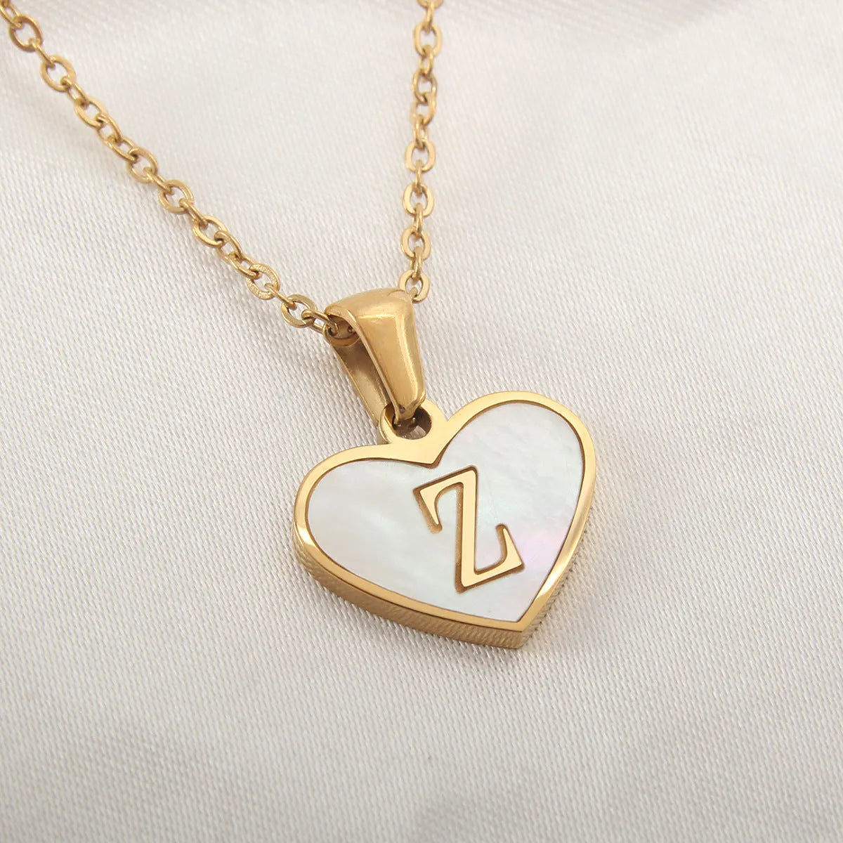 Gold plated chain necklace with a white shell heart-shaped pendant personalised with a single letter initial.