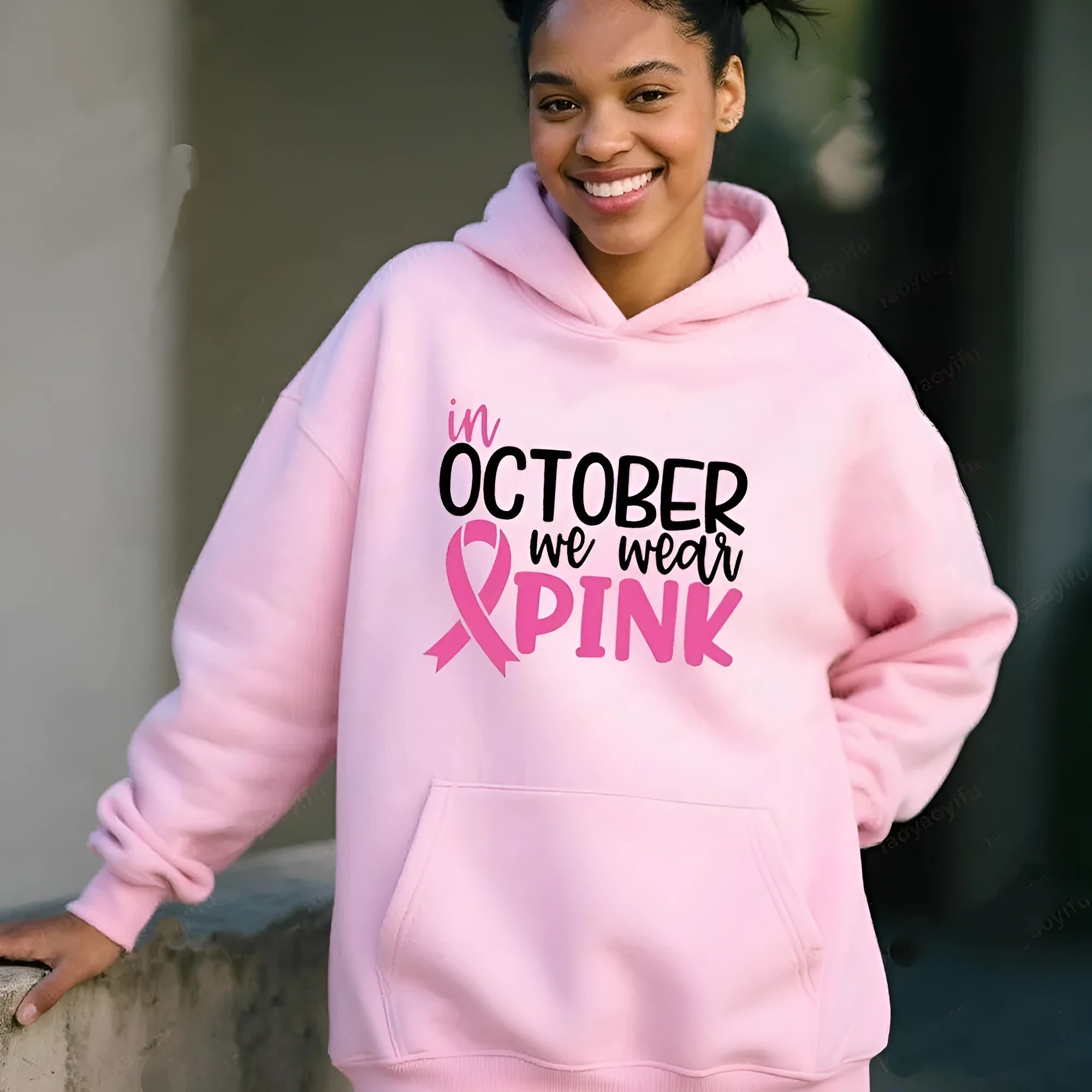 Woman wearing a pink retro pattern sweatshirt hoodie with side pocket.