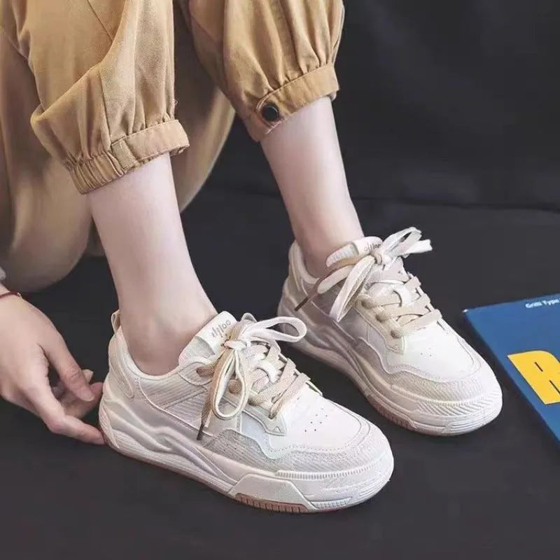 Women's pink and beige low-top sneakers with a rubber sole for height increase.