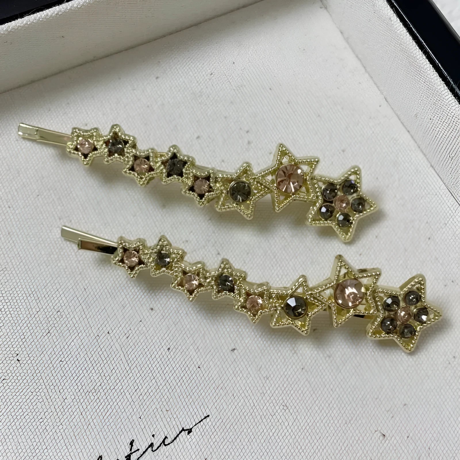 Gold-coloured Korean style hair barrette with a star and letter decoration, shown as a side clip for bangs.