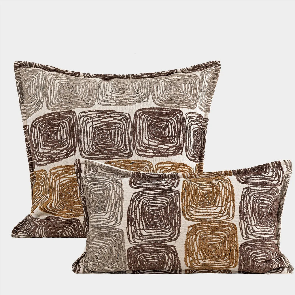 Abstract coil pattern cushion cover with piping trim in cream and coffee colours