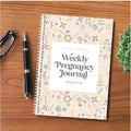 A5 pregnancy weekly diary notebook open showing weekly pregnancy journal pages