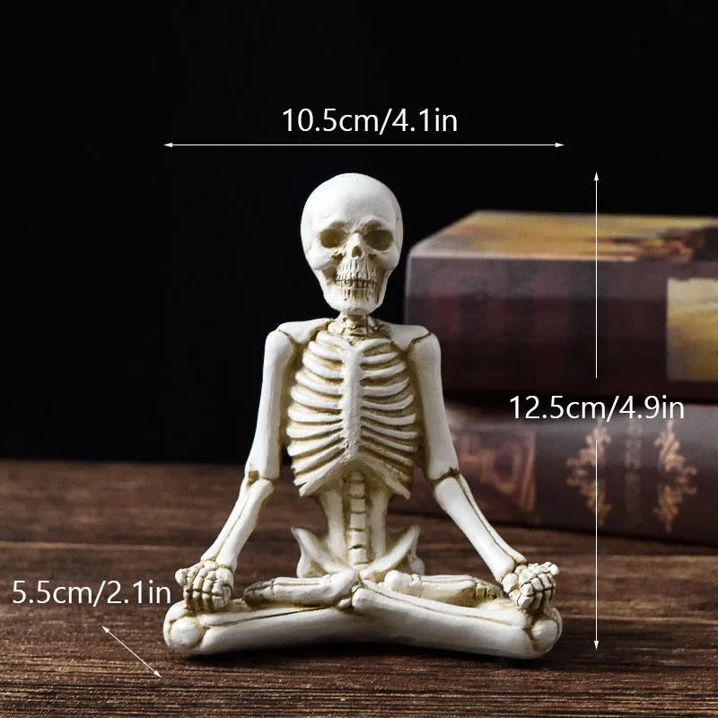 A detailed resin desktop ornament of a yoga-pose skeleton skull in black and white colour options.