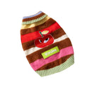 Corgi dog wearing a rainbow apple striped knitted pullover sweater in brown, standing on grass