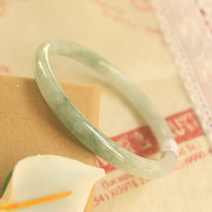 Green jade waxy student bracelet with geometric Chinese design showing adjustable sizing options
