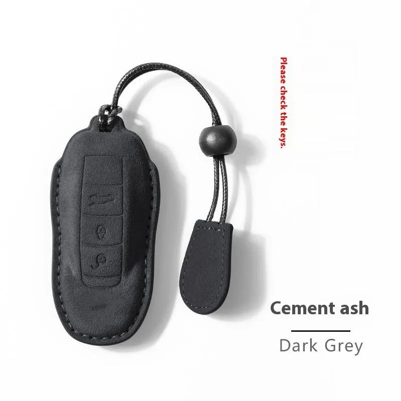 Suede car key cover shown in Cement Grey, Dark Green, Light Grey, and Orange colour options.