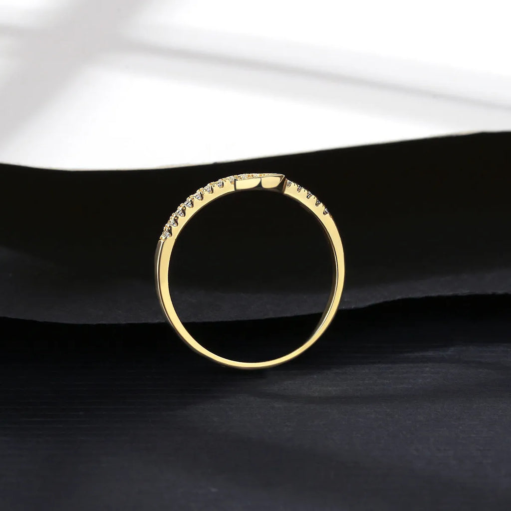S925 silver bow ring with single row of diamond stones on a plain background