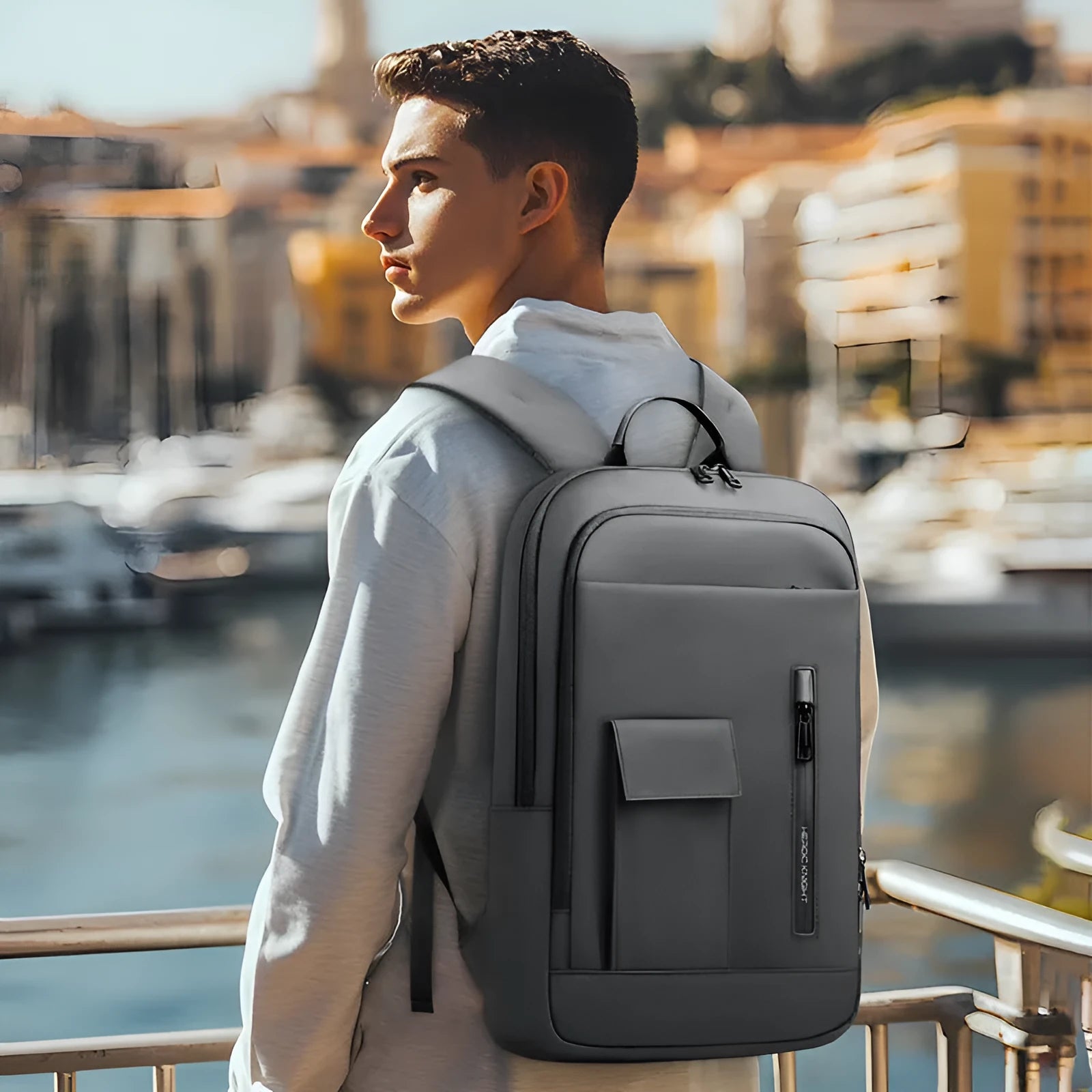 Lightweight Oxford cloth men's backpack in dark grey with sewing line details, shown from the side.
