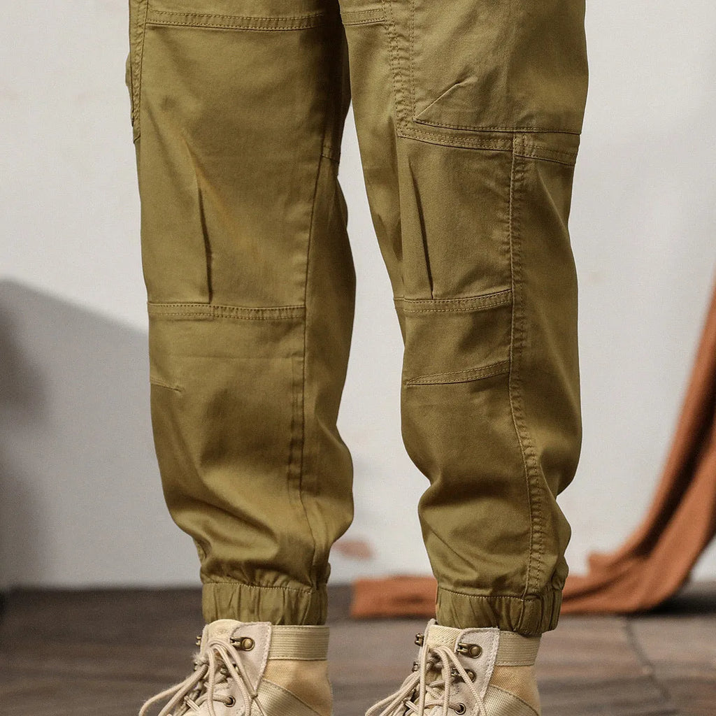 Men's khaki cotton tapered harem pants with a small ankle opening and mid-waist design on a neutral background.