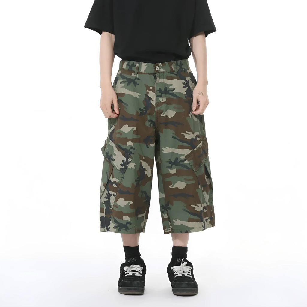 Men's cropped length camouflage cotton wide-leg jeans with large side pockets on a plain background.