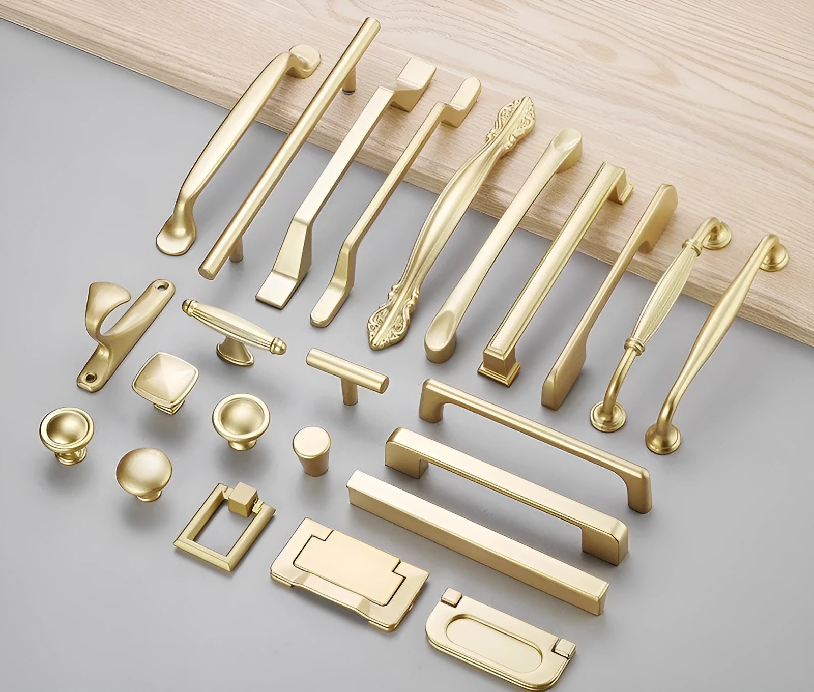 Gold coloured T-shaped aluminium alloy single hole cabinet door handle on a white background.