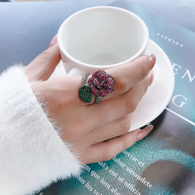 Gold-plated copper ring with geometric flower design and simulation red corundum in black gold finish