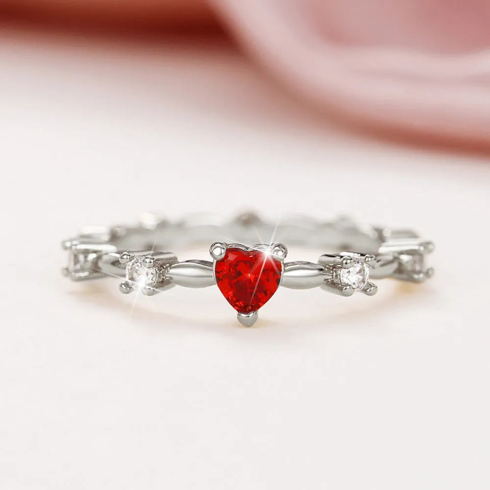 Gold or silver peach heart-shaped ring with clear zircon stones on a copper band.
