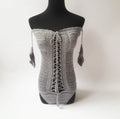 Women's off-the-shoulder one-piece swimsuit on a hanger, available in white, black, and other colours.
