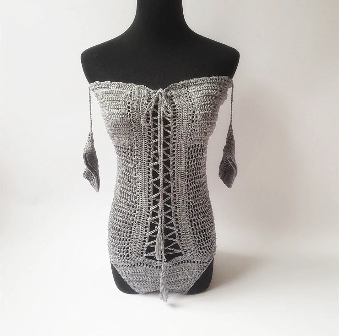 Women's off-the-shoulder one-piece swimsuit on a hanger, available in white, black, and other colours.