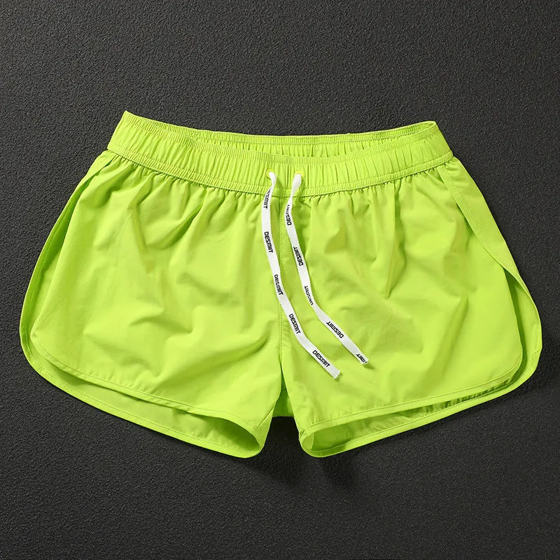 Men's loose elastic polyester shorts in orange, fluorescent green, and black colours for beach surfing.