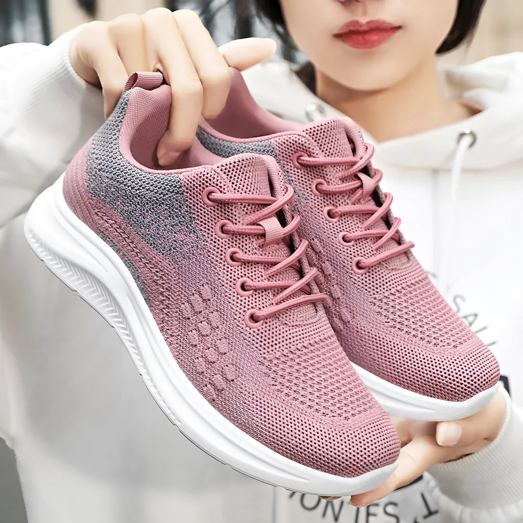 Women's black mesh low-top sneakers with round toe and white PVC sole on a neutral background.