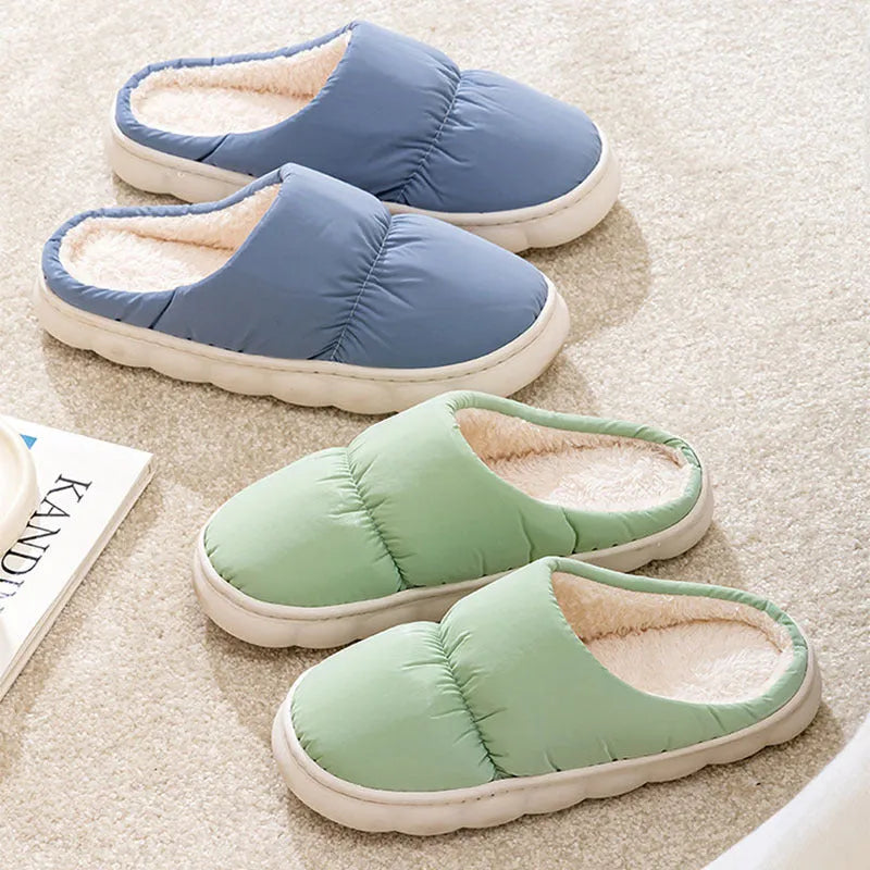 A pair of thick-soled indoor slippers with an artificial leather upper and soft plush lining, shown in a choice of colours.