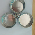 A small stainless steel egg steamer in a heart shape next to a round version, for cooking eggs on a hob.