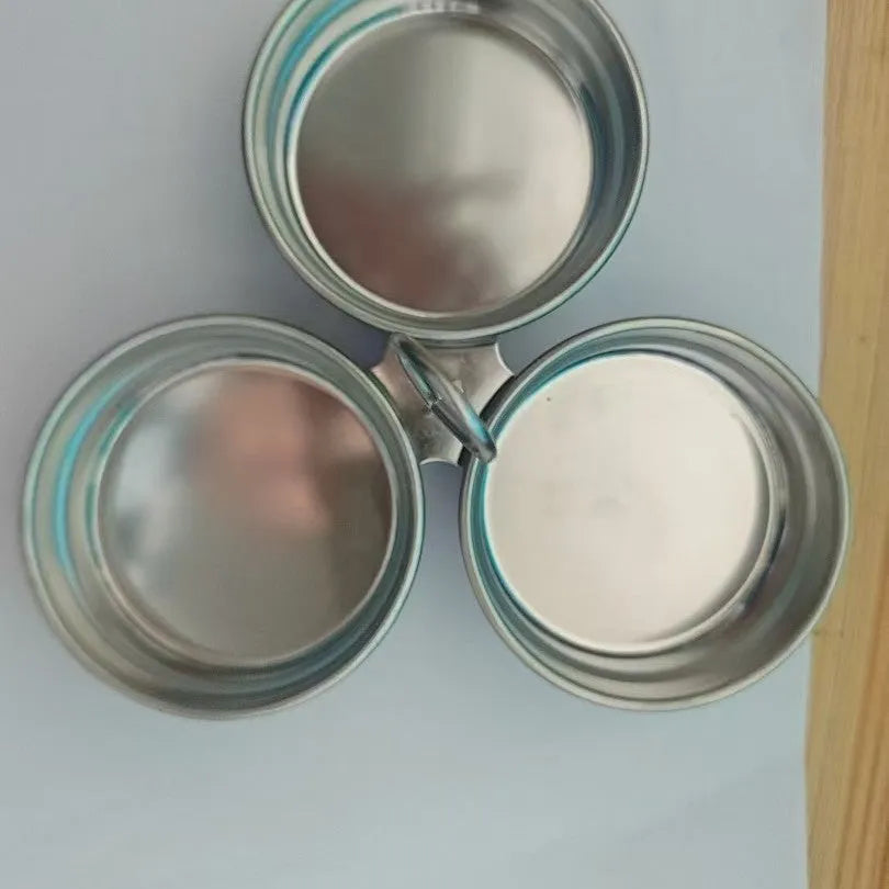 A small stainless steel egg steamer in a heart shape next to a round version, for cooking eggs on a hob.