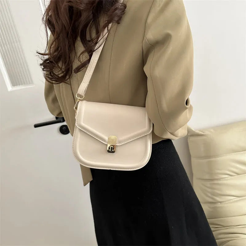 Soft PU leather clamshell shoulder messenger bag in horizontal square shape on adjustable strap.
