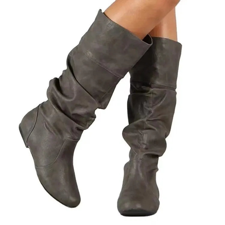 Women's flat ankle boots in black with round toe, high cylinder shaft, slip-on design and rubber sole.