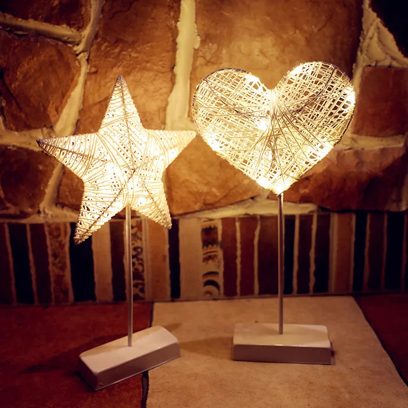 Rattan woven star-shaped LED table lamp with copper wire details on a table.