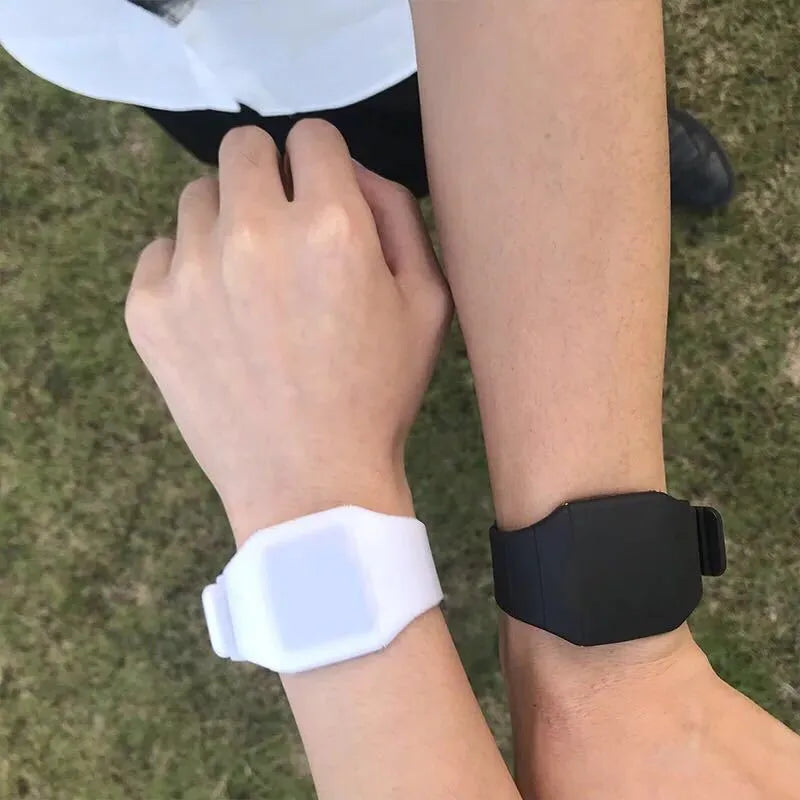 Square electronic touch screen watch with plastic case and PU strap on a wrist.