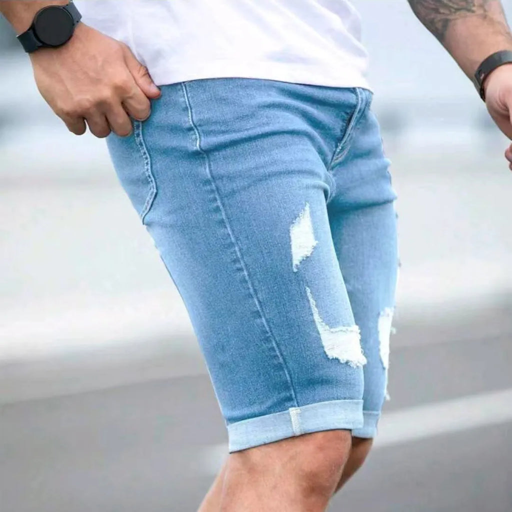 Sky blue men's denim shorts with distressed multi-hole detailing and low waist design