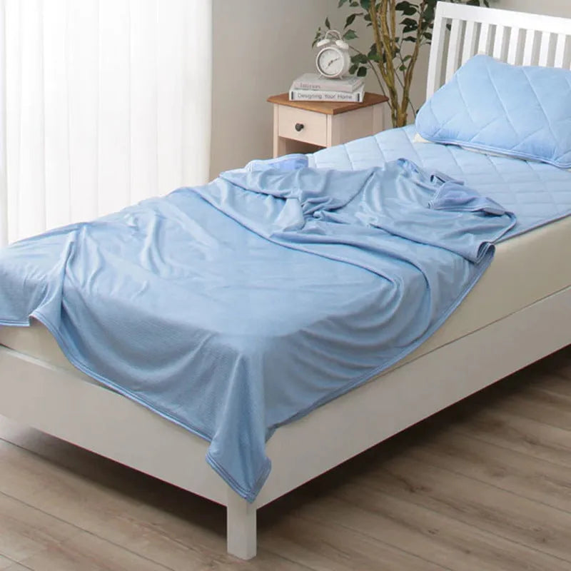 Blue and grey polyester cooling blanket with Japanese Q-Max fibres on a bed.