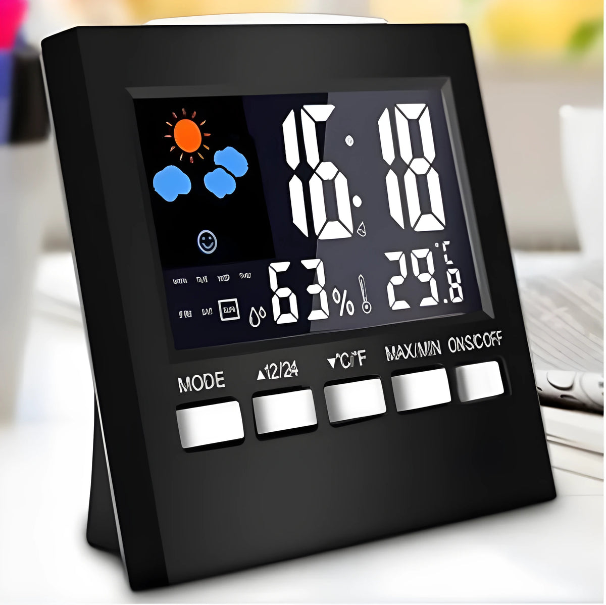 Black digital alarm clock thermometer displaying temperature and time on a desk