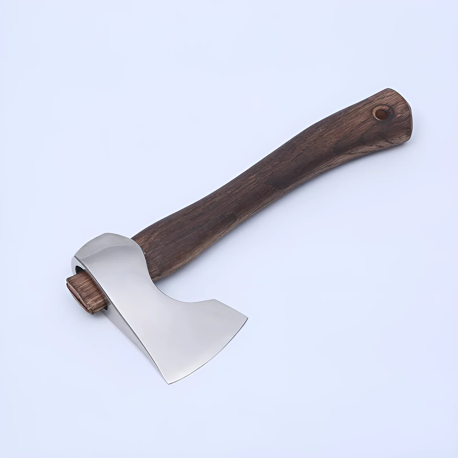 Camping axe with a high-carbon steel head and a wooden handle on a neutral background