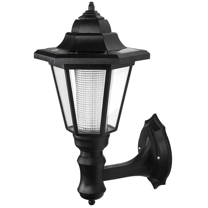 Outdoor solar hexagonal wall light in garden setting, available in white or yellow light, with ground plug or wall hanging style